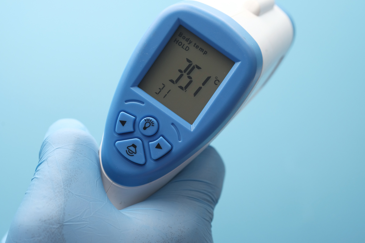 Hand Holding Infrared Thermometer to Measuring Temperature.